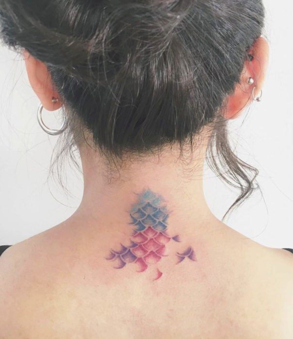 Diseños bonitos de tatuajes de acuarelas; tatuaje de escaas de sirena en colores pastel en la espalda, cuello
