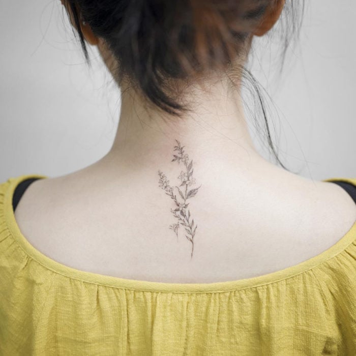 Tatuaje mini, pequeño de flores femeninas en la espalda