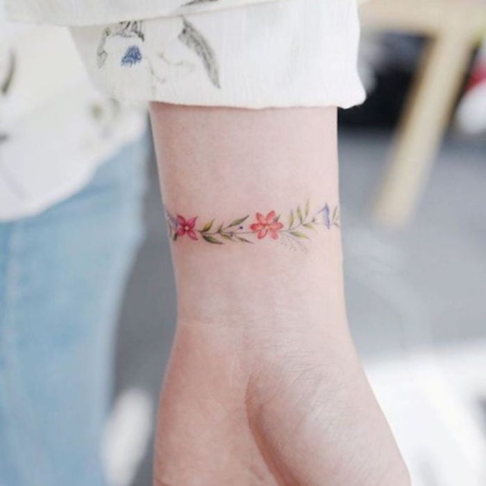 Mini, small tattoo of feminine flowers on the wrist as a bracelet