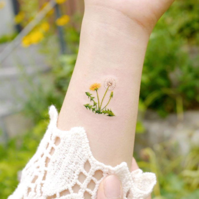 Tatuaje mini, pequeño de flores femeninas blancas y amarillas, dientes de león en el brazo