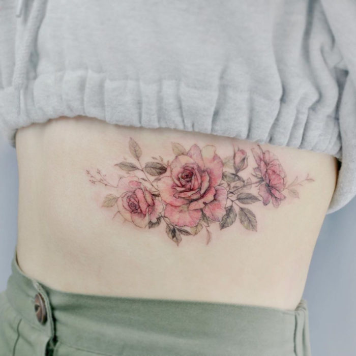 Tatuaje mini, pequeño de flores femeninas rosas en las costillas