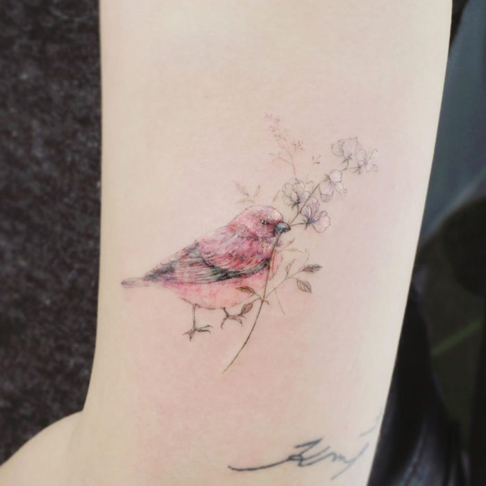 Tatuaje mini, pequeño de flores femeninas blancas con un pájaro en el brazo