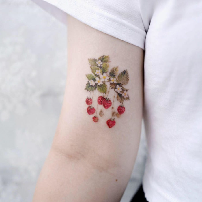 Tatuaje mini, pequeño de flores femeninas fresas en el brazo, bícep