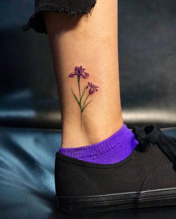 Tatuaje de flor morada en el tobillo