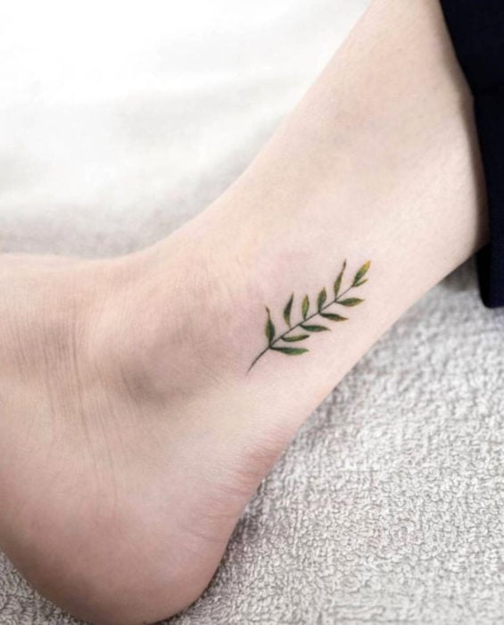 Tatuaje de hojas verdes en el tobillo