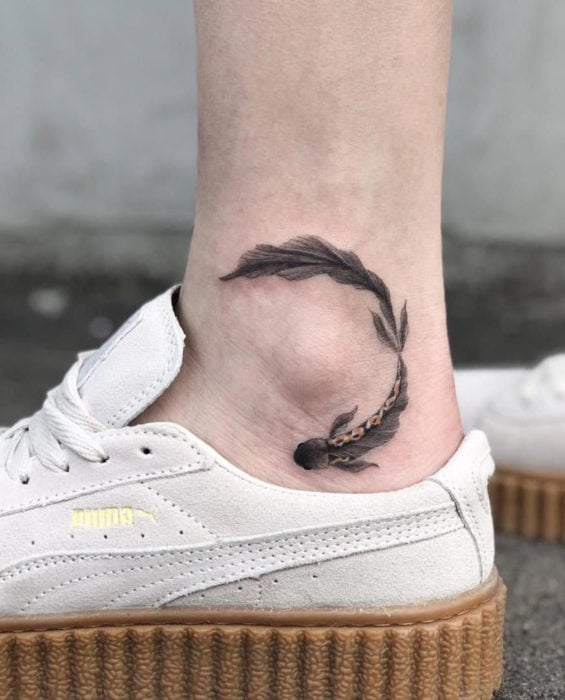 Tatuaje de pez beta negro en el tobillo