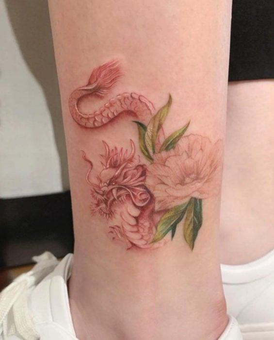 Tatuaje de dragón chino con flor en el tobillo