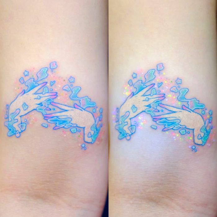 Tatuadora hace tatuajes bonitos, delicados y femeninos que brillan; tatuaje de manos colores pastel en el brazo