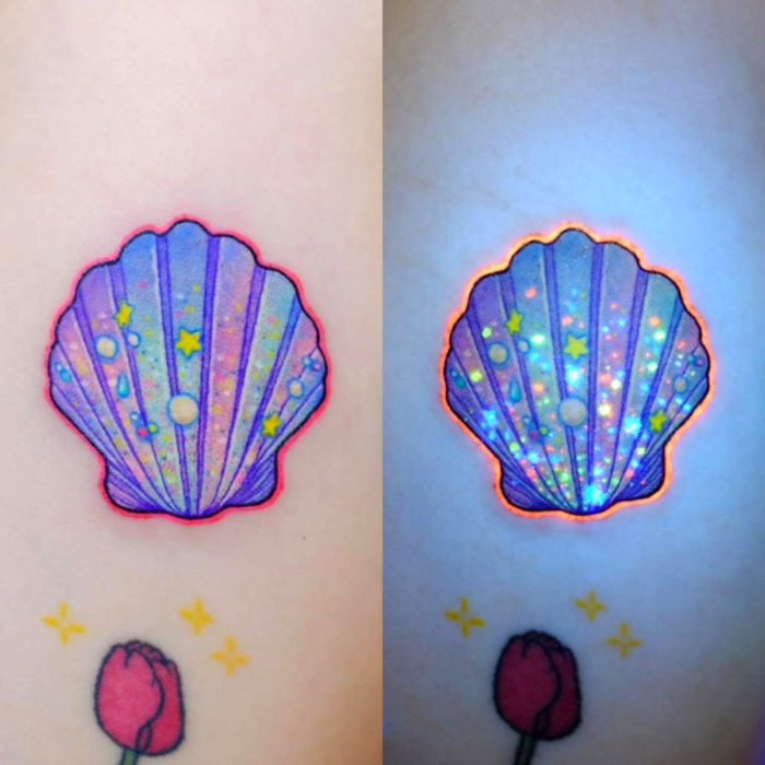 Tatuadora hace tatuajes bonitos, delicados y femeninos que brillan; tatuaje de concha de mar color azul, morado y rosa pastel en el brazo