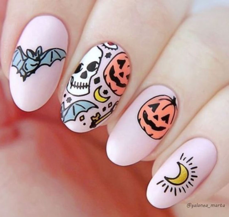 Uñas inspiradas en Halloween con diseño de color rosa, calaveras, murciélagos y calabazas