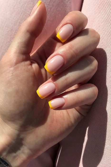 Diseño de manicura en uñas cortas en fondo nude y tipo francés en color amarillo