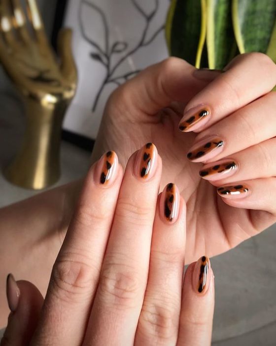 Manicura en diseño animal print en base transparente y una línea en medio en cada dedo con dicho diseño