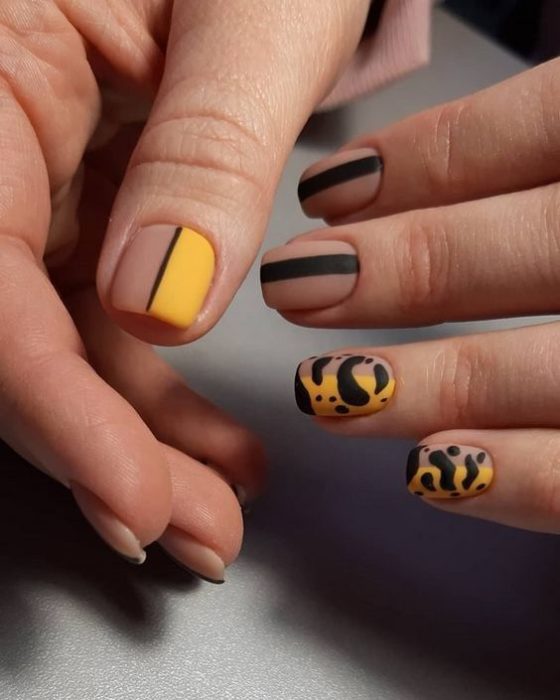 Manicura en diseño animal print en colores negro y mostaza con efecto mate