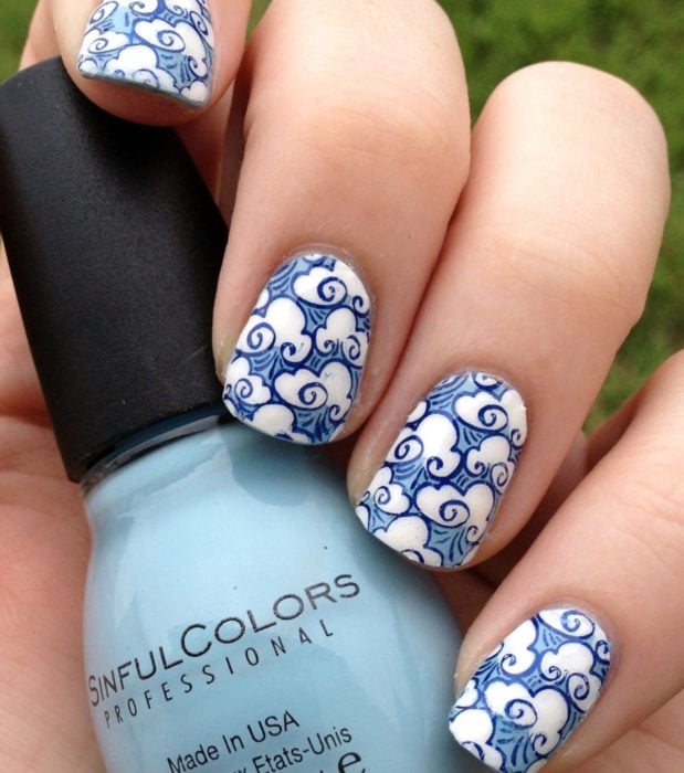 Manicura con diseño de cielo y nubes; uñas cortas cuadradas pintadas con esmalte azul
