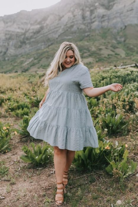 Chica plus size rubia de cabello largo y ondulado con vestido azul celeste con vuelo