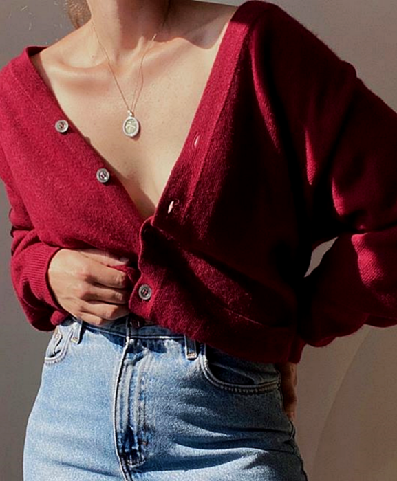 chica usando un cárdigan rojo con botones y jeans a la cintura