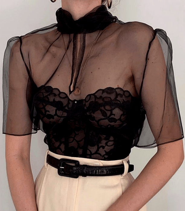 blusa negra de organza con corsét negro de encaje, manga corta y cuello alto con pantalón de vestir color crema a la cintura con cinturón de piel negro