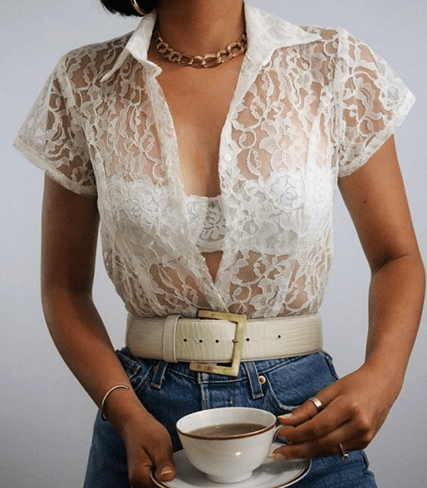 camisa de botones blanca de encaje con manga corta y cuello de vestir, cinturón blanco de piel, jeans a la cintura y collar de eslabones dorados