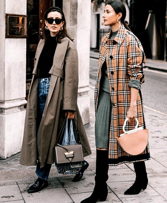 chica de cabello castaño usando lentes de sol, top negro, abrigo largo café, jeans, zapatos loafers negros y bolso gris, chica de cabello castaño usando un suéter azul, falda tejida azul, botas largas negras de tacón y abrigo burberry largo con bolso naranja