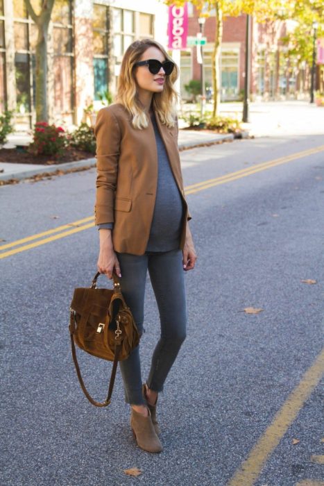 Chica usando un outfit de maternidad de jeans, saco color café y botines 