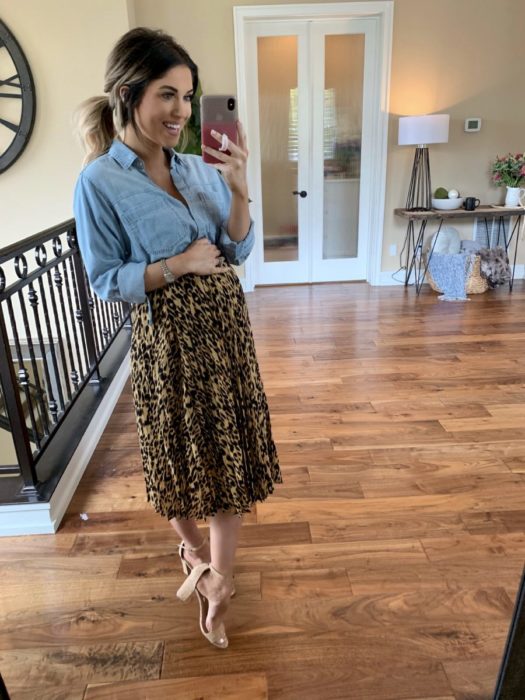 Chica usando un outfit de maternidad de falda con blusa de mezclilla y zapatos color nude 