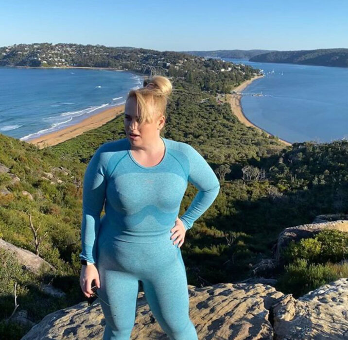 Rebel Wilson usando un conjunto deportivo color azul y posando después de haber hecho hicking