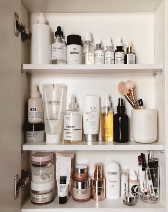 Organización de maquillaje y skin care dentro de las puertas del espejo del baño