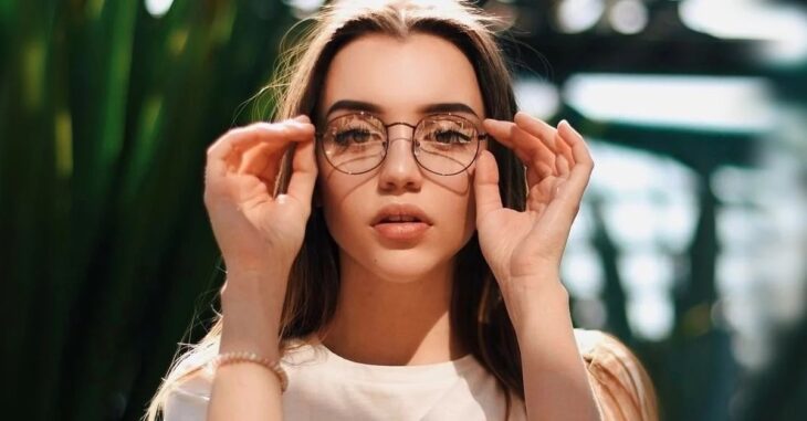 Chica sosteniendo sus anteojos