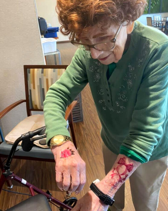 Abuelitos en asilo se hacen tatuajes temporales; flor y moño en las muñecas