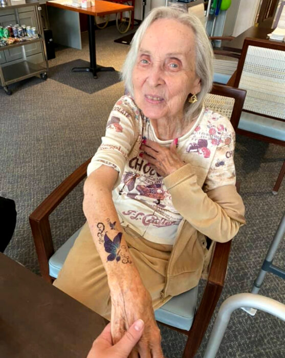 Abuelitos en asilo se hacen tatuajes temporales; mariposa en el brazo