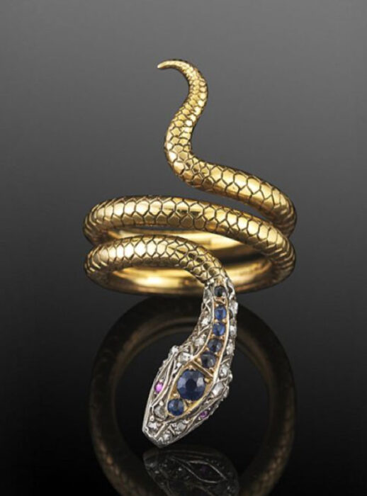 Anillo en forma de serpiente con piedritas color azul en la cabeza