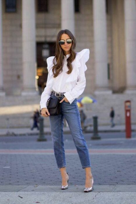 Chica con una blusa de color blanco con jeans y tacones 