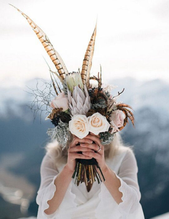 Ideas para una boda vikinga; ramo de flores y plumas