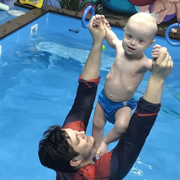 Hombre enseñando a su hijo con síndrome de Down a nadar