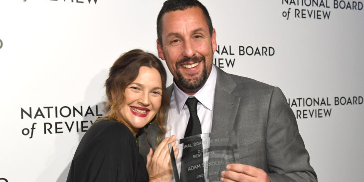 Adam Sandler y Drew Barrymore abrazados mientras posan juntos después de recibir un premio 