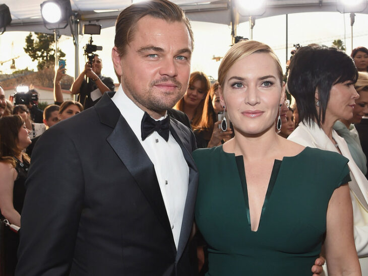 Kate Winslet y Leonardo DiCaprio abrazados mientras posan para una fotografía en la alfombra roja 