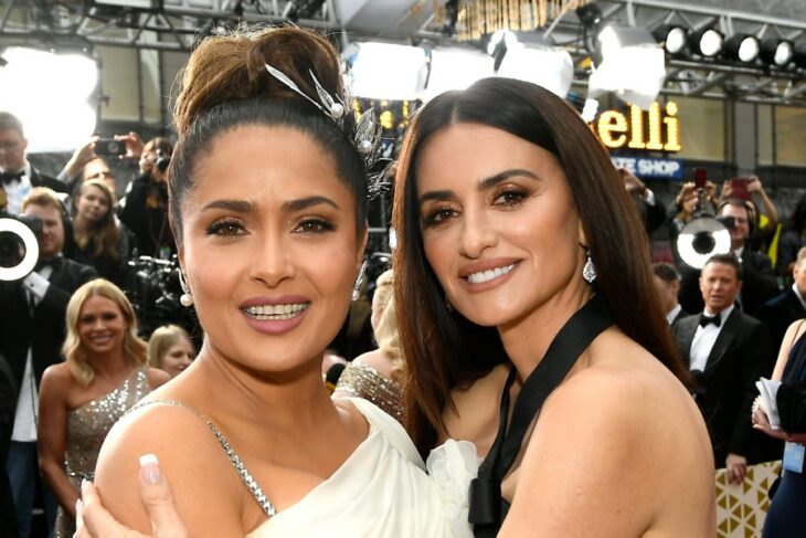 Salma Hayek y Penélope Cruz abrazadas mientras posan para una fotografía en una alfombra roja 