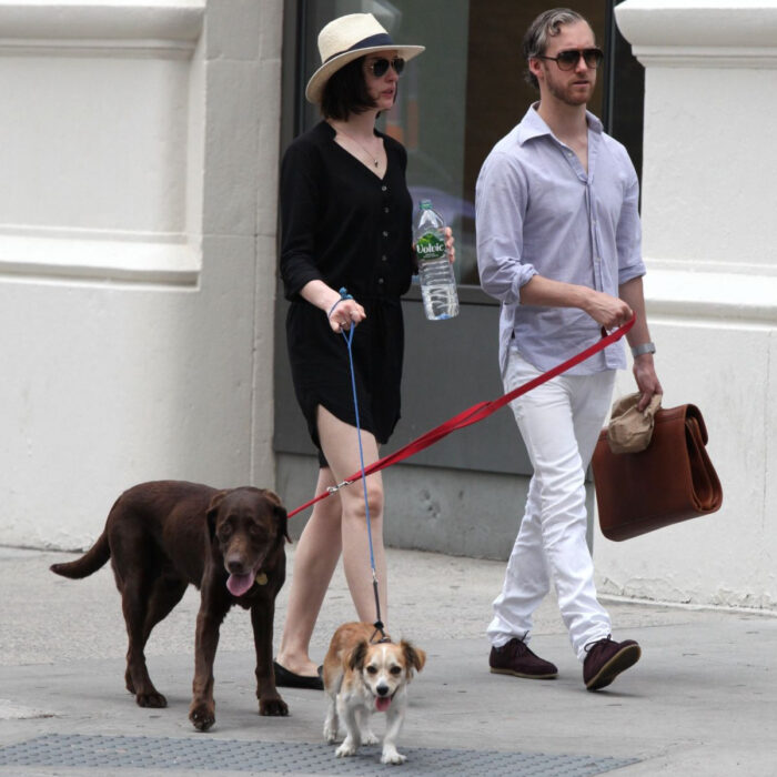 Famosos que han adoptado mascotas, perros o gatos; Anne Hathaway dando un paseo con sus perritos Kenobi y Esmeralda, labrador café y mestizo color miel