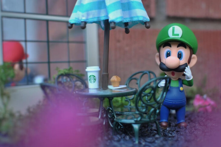 Artista toma fotografías de figuras miniatura de personajes de películas, series y videojuegos; Mario Bros, Luigi en Starbucks