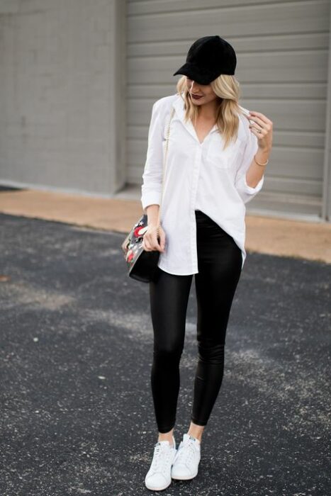 Chica usando una camisa blanca junto con unos leggins de color negro y flats 