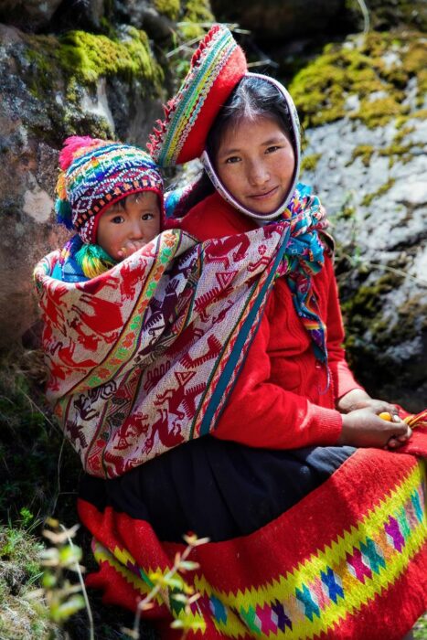 Fotografía de Mihaela Noroc, cargando a su bebé en un reboso 