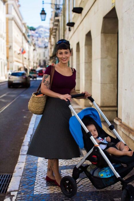 Fotografía de Mihaela Noroc, mujer paseando a su bebé en carriola 