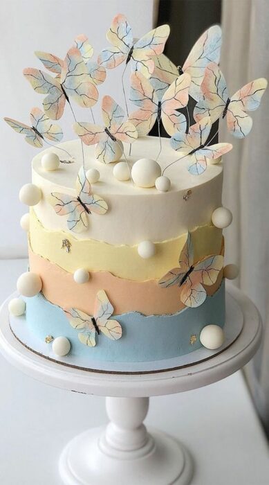 Pastel de sabores decorado con mariposas de tonos tenues; Hermosos pasteles con mariposas