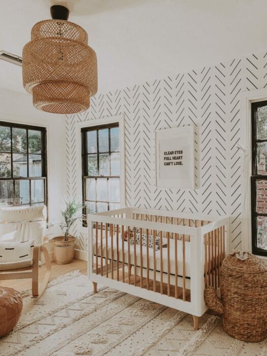 Decoración de la habitación de un bebé en tonos dorados con una cuna de madera de color blanco con café, mesedora y mueble para guardar artículos 