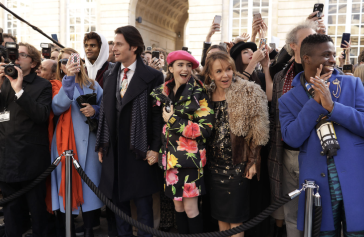 Lily Collins trägt einen schwarzen Mantel mit Blumendruck auf der Emily in Paris-Serie