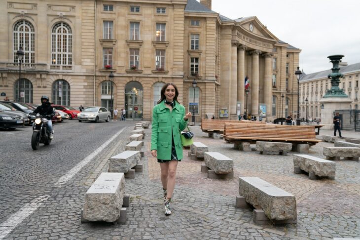 Lily Collins usando un abrigo de color verde en la serie Emily in Paris