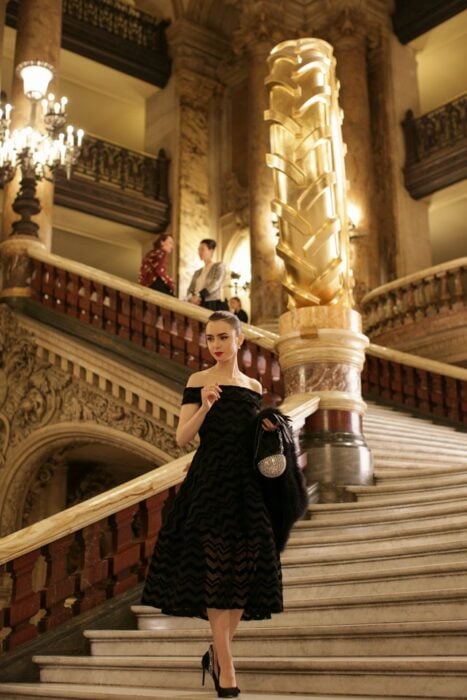 Lily Collins trägt ein schwarzes Kleid in der Emily in Paris-Serie