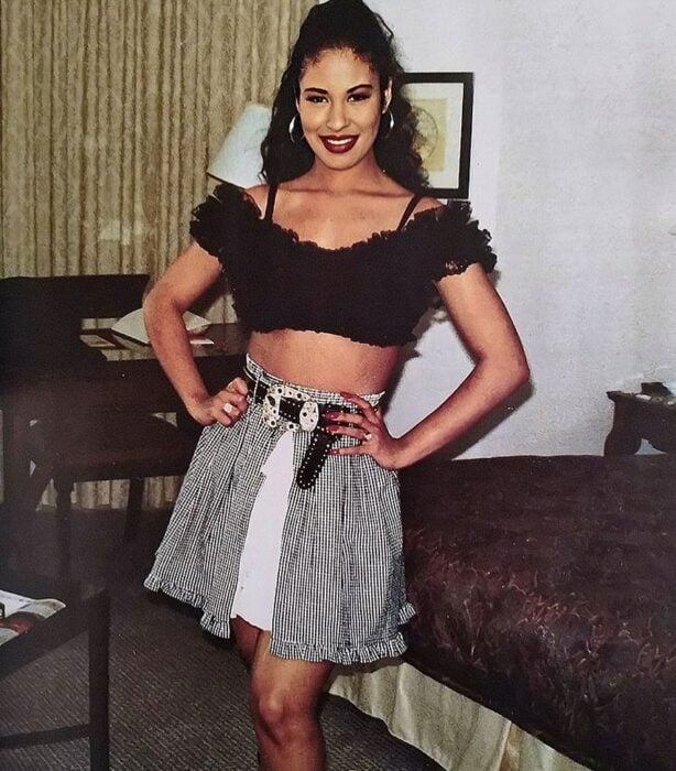 Selena Quintanilla usando una falda y crop top de color negro 