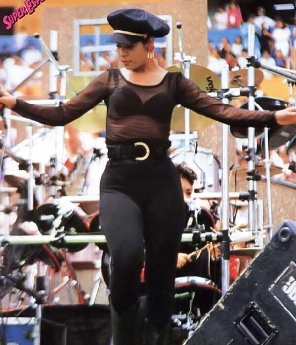 Selena Quintanilla usando un outfit totalmente negro con una boina negra de pedrería 