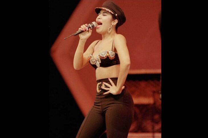 Selena Quintanilla usando unos leggins de color negro con un bustie de pedrería y boina de color negro 